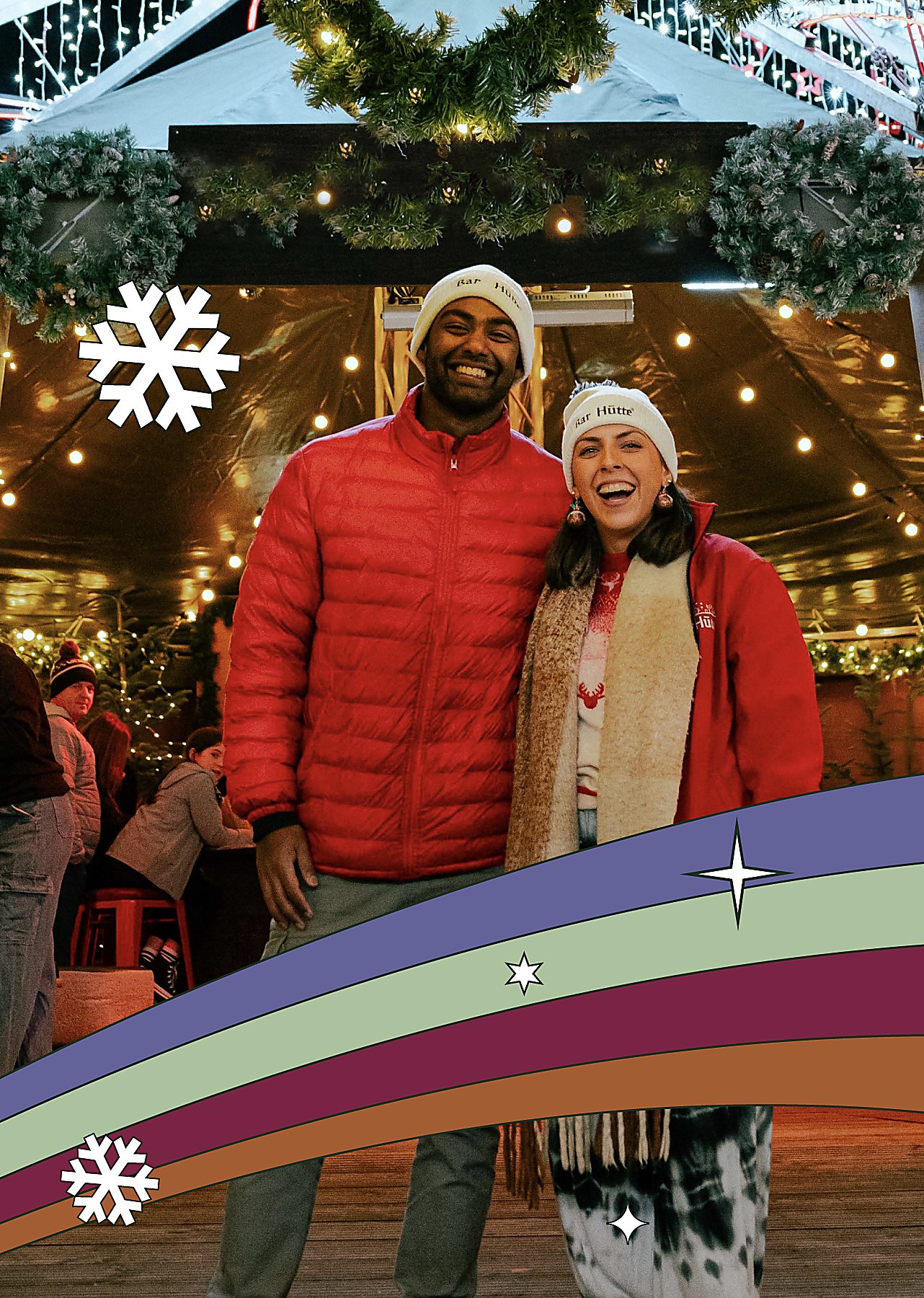 Two people stood infront of a Christmas bar with decorations around them.