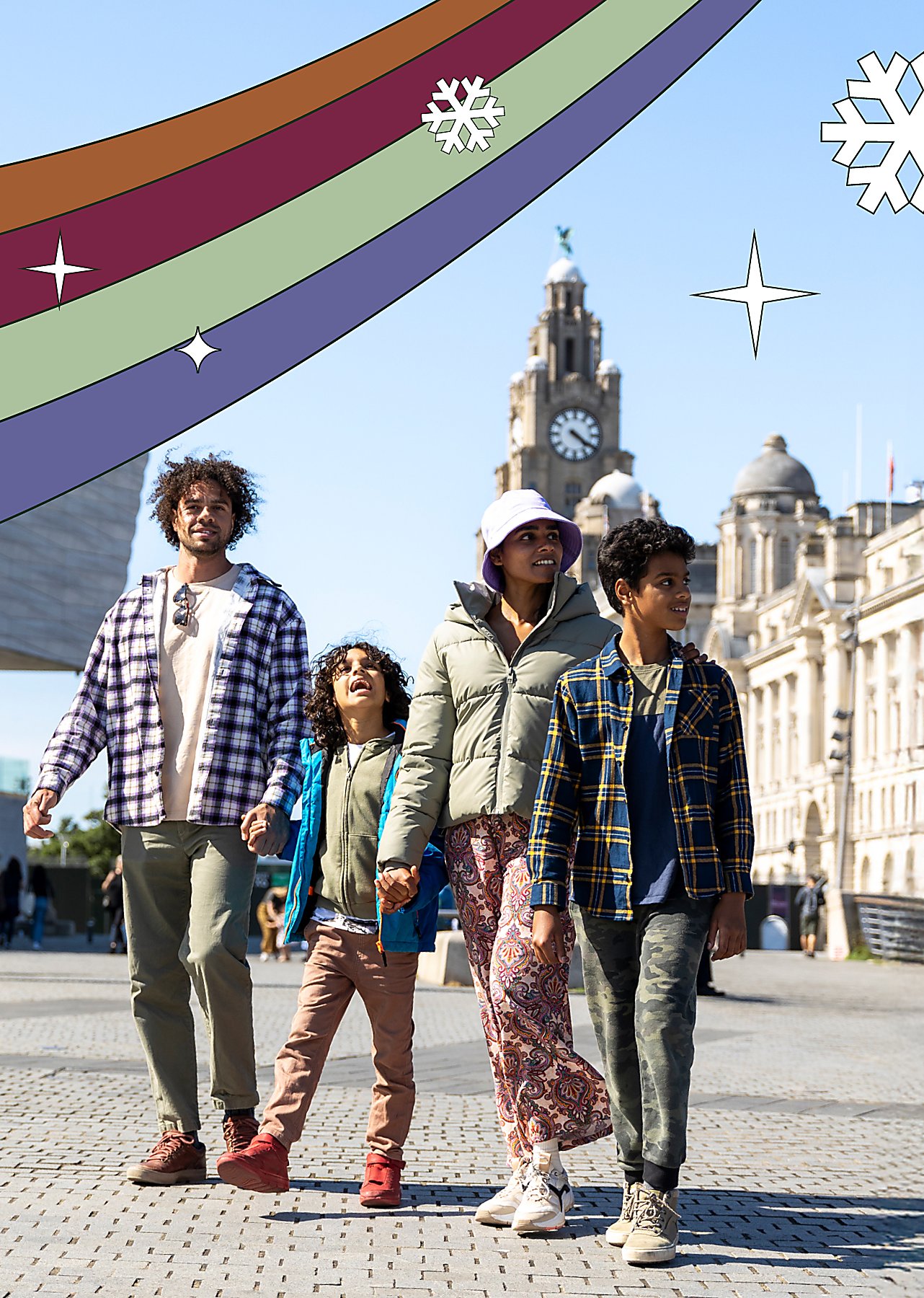 A family of four with two adults and two children walking along Liverpool's Pier Head.