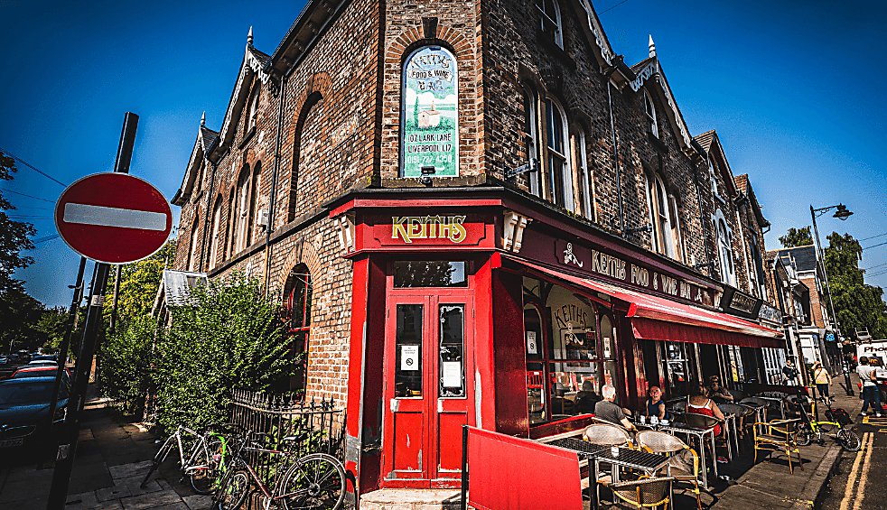 An exterior shot of a cafe with an old Victorian Style shop front painted red