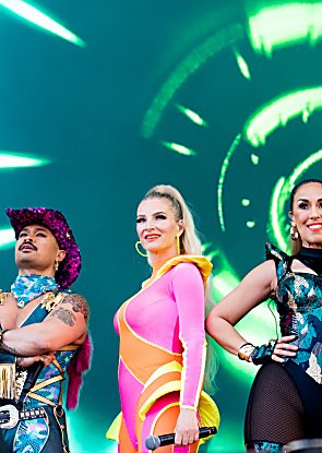 The Vengaboys standing on stage in bright, flourescent outfits