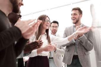 A group of people are at a corporate event, applauding.
