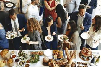 A group of people lined up to get food at a banquet.