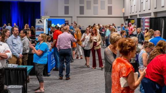 Chamber Mixer guests mingling in between various vendor booths inside of the exhibit hall
