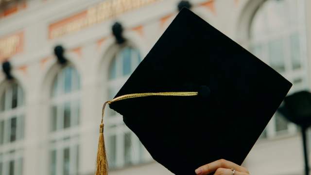 Hand holding Graduation Cap