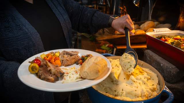 Person holding a plate of food while going through a buffet