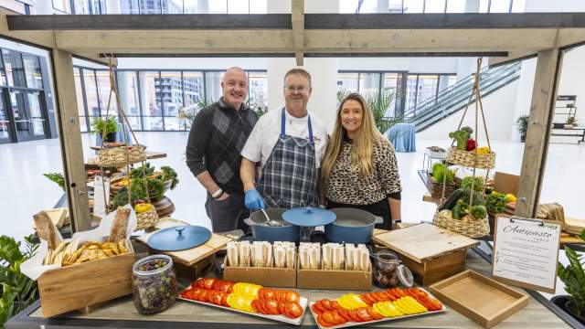 Three team members stand behind a fresh antipasto station inside First Financial Center.