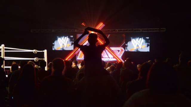 Child on a parents shoulders during a WWE event