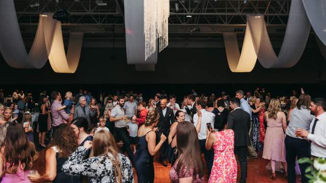 Large crowd dancing on a dance floor during a wedding reception