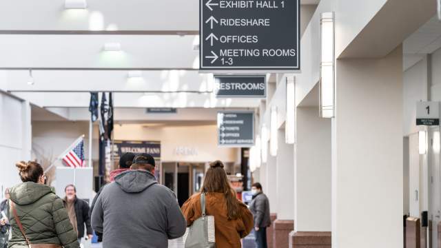 Attendees walking towards the Guest Services office during an event