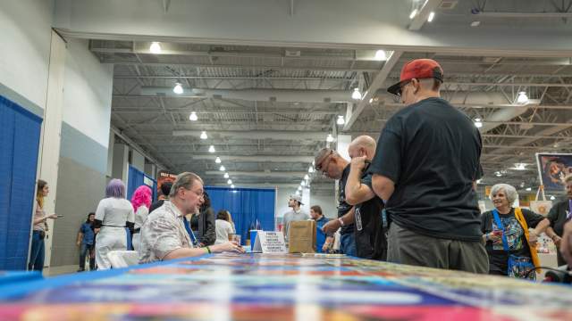 image of people interacting with a booth at a show inside the Tucson Convention center
