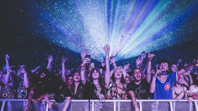 A group of fans standing on the floor for a concert