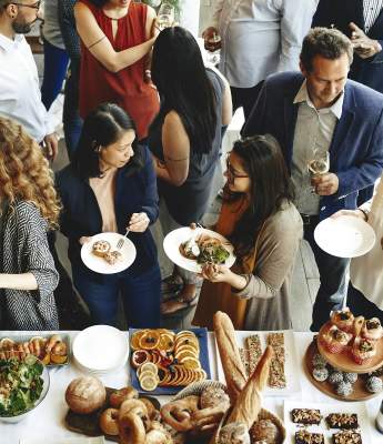 A group of people lined up to get food at a banquet.