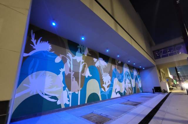 colorful floral mural on an outside wall at night by Atalie Gagnet