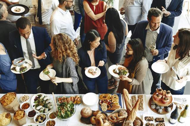 A group of people lined up to get food at a banquet.