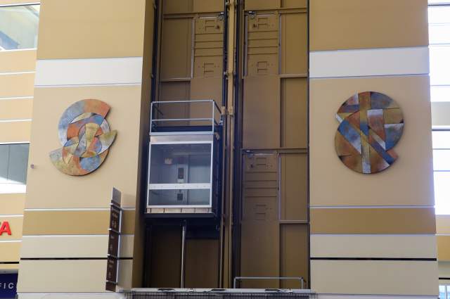 Untitled sculpture by Stan Myer - Two sculptures hanging on either side of elevators