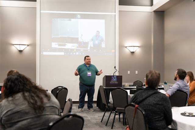 Male Speaker In Front of Presentation Screen