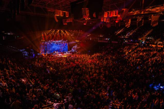 View of an arena during a concert with the audience bathed in orange light