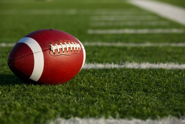 A football laying on a field.