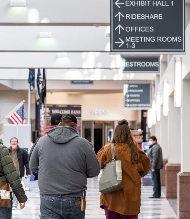 Attendees walking towards the Guest Services office during an event