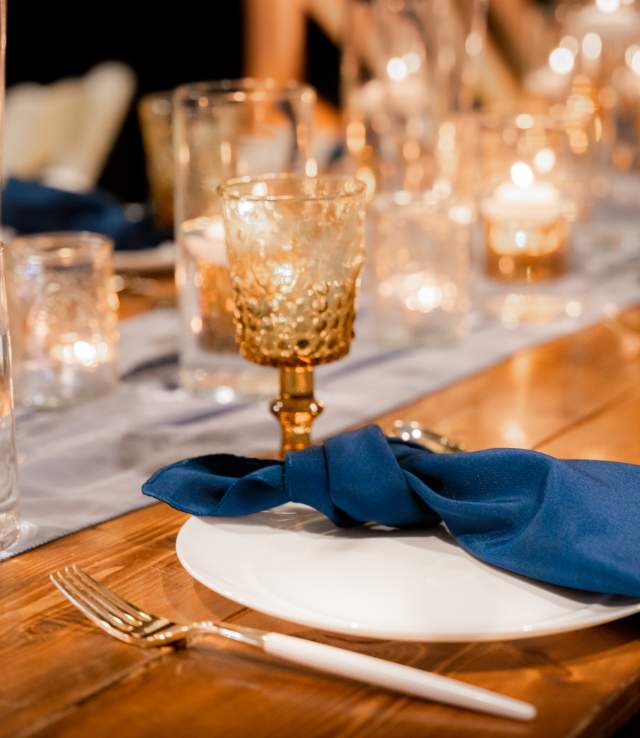Golden goblets glasses and blue linen napkins for a place setting