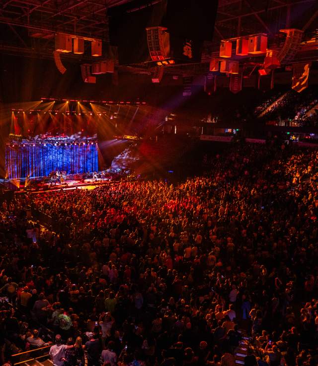 View of an arena during a concert with the audience bathed in orange light