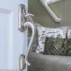 view of door handle on open door with vacation rental living area in background