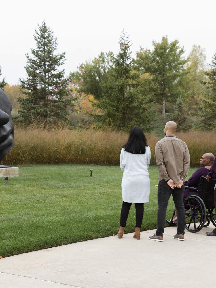 Visitors taking Igor Mitoraj's Light of the Moon - Further Out Frederik Meijer Gardens & Scuplture Park.