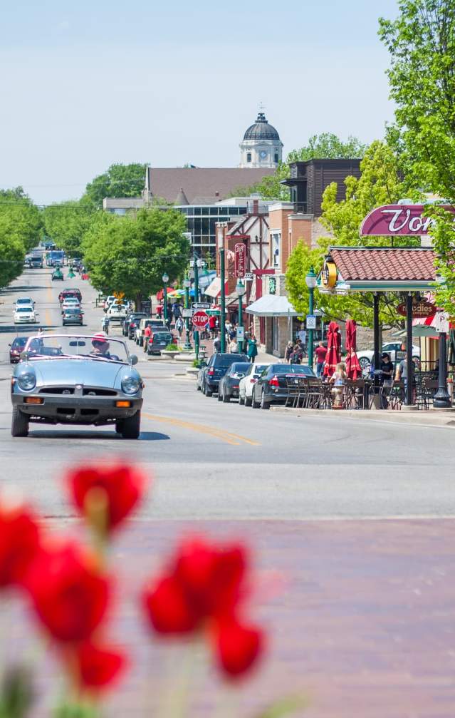 Classic car drives past tulips on Kirkwood in Bloomington