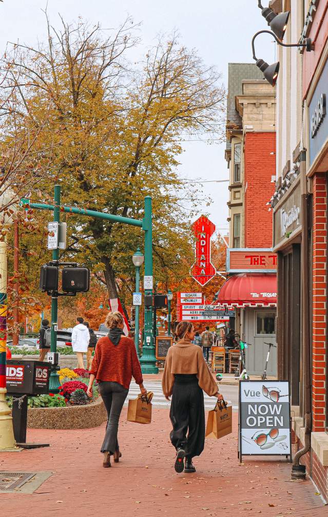 Two women walking with shopping bags toward the Buskirk-Chumley Theater