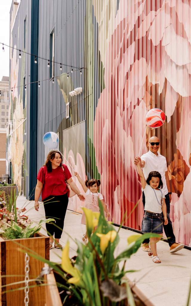 A family strolls along The Landing enjoys public art in Fort Wayne, Indiana.