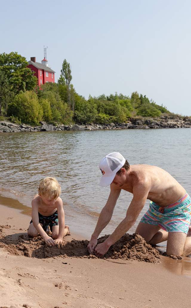 A father and son at the beach near the Marquette Harbor Lighthouse, located in the Upper Peninsula of Michigan