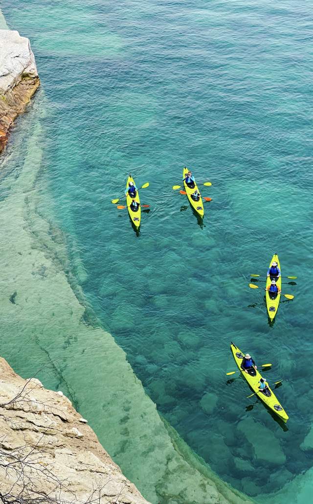 Image of kayaks in the crystal blue water of Lake Superior at Pictured Rocks National Lakeshore, located in the Upper Peninsula of Michigan