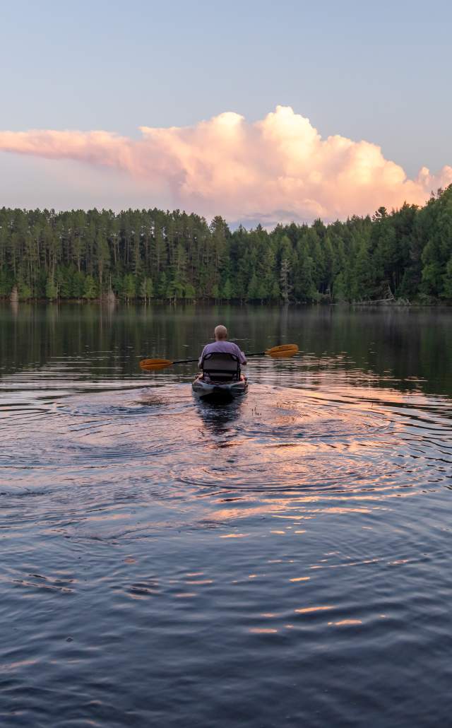 A man kayaking at sunset at Sylvania Wilderness Area.
