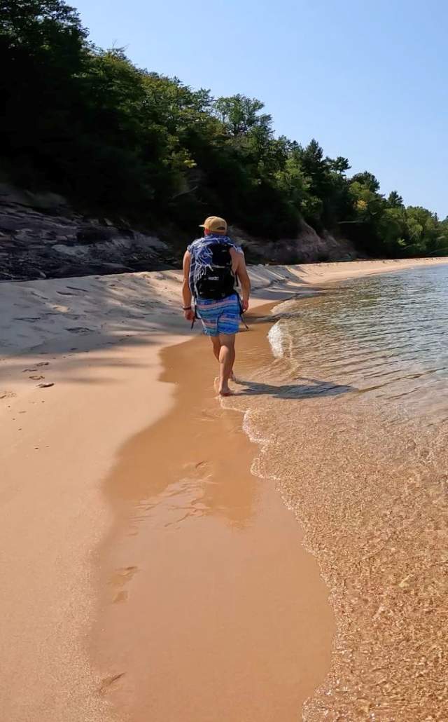 A man walking along the beach at Grand Island in the Upper Peninsula