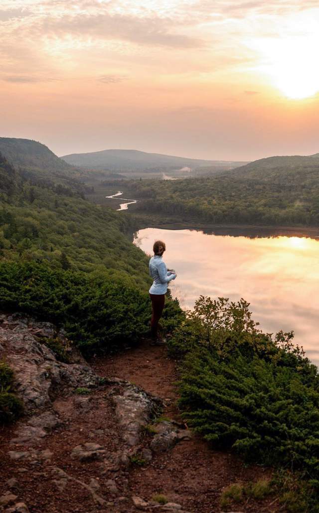 woman overlooking the Lake of the Clouds at sunrise