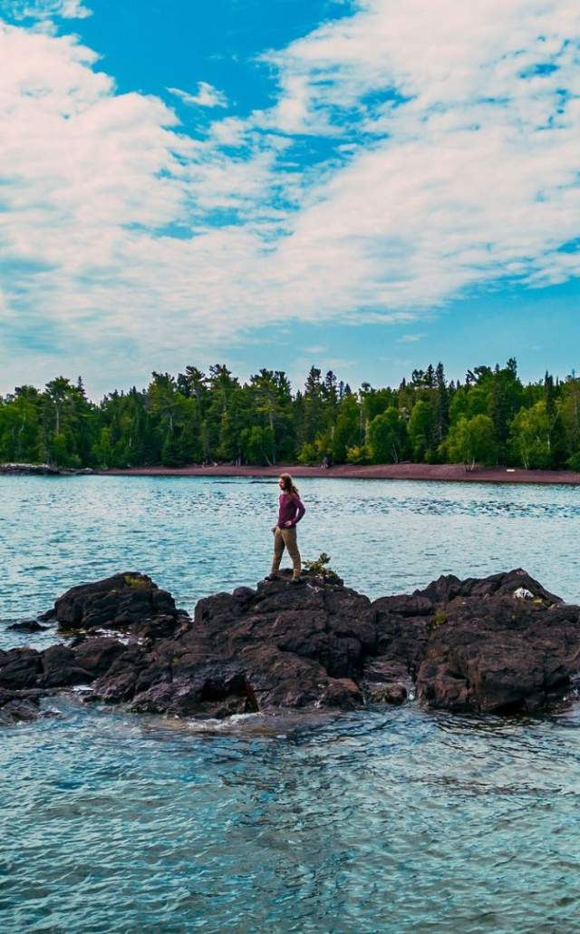 A man on a rock outcropping on Lake Superior in the Upper Peninsula of Michigan