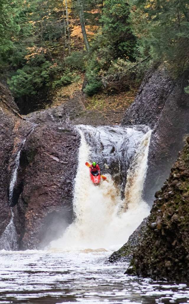 A man kayaking over Gorge Falls, located in the Upper Peninsula of Michigan