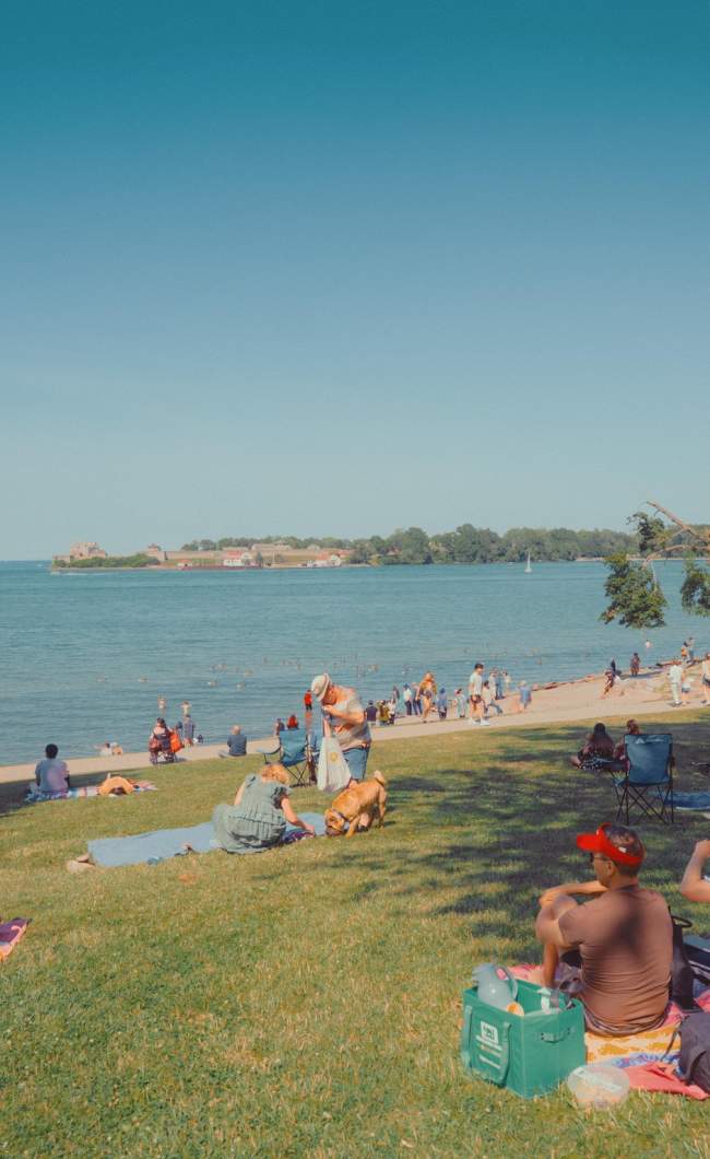 People sitting on blankets by waterfront