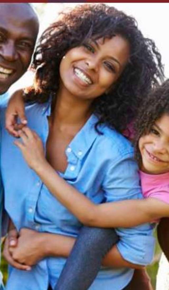 Multigenerational family smiling and embracing together at an outdoor family reunion