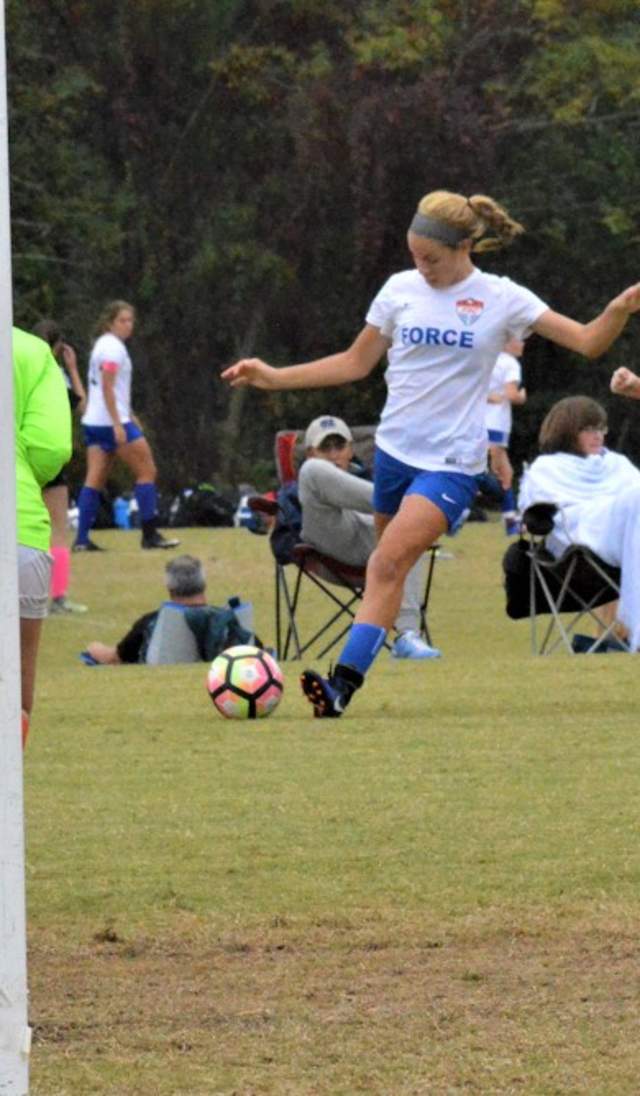 A young soccer player works the ball toward the goal while the keeper and defenders get ready, showing the kind of active, well-used fields planners look for when hosting tournaments.