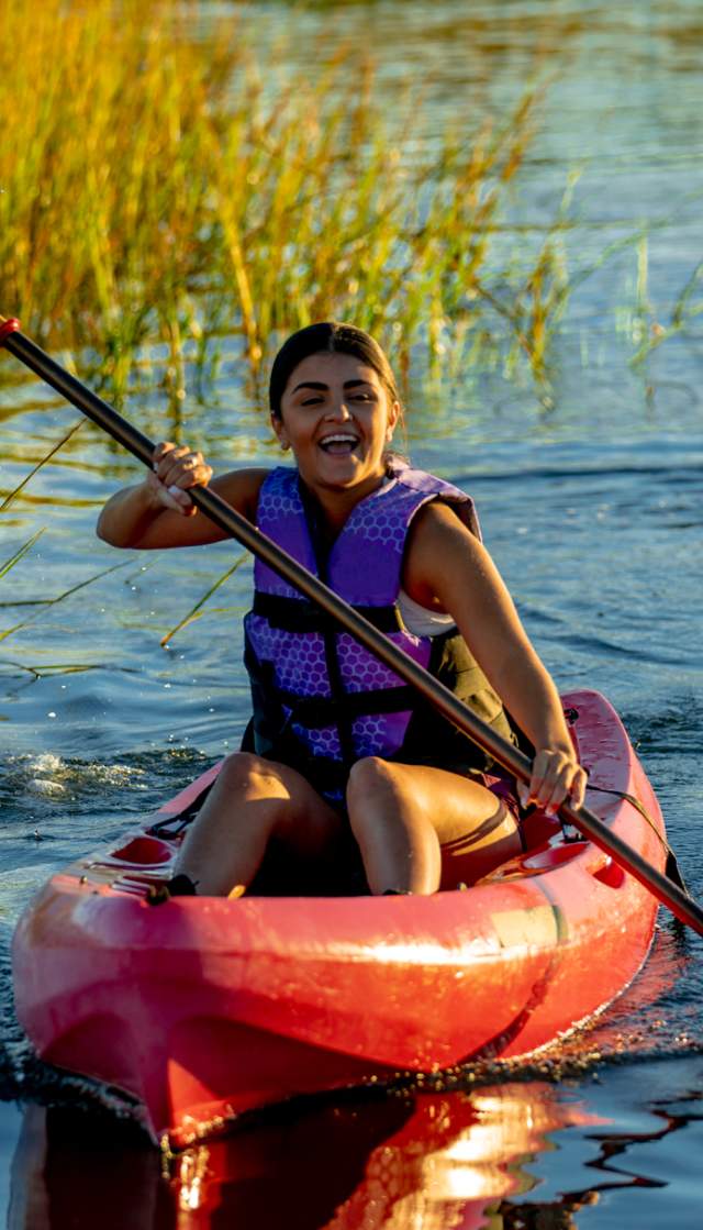 a woman kayaking in the marsh