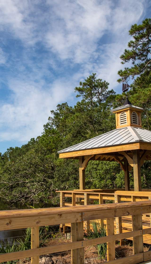 wooden gazebo and walkway overlooking a river
