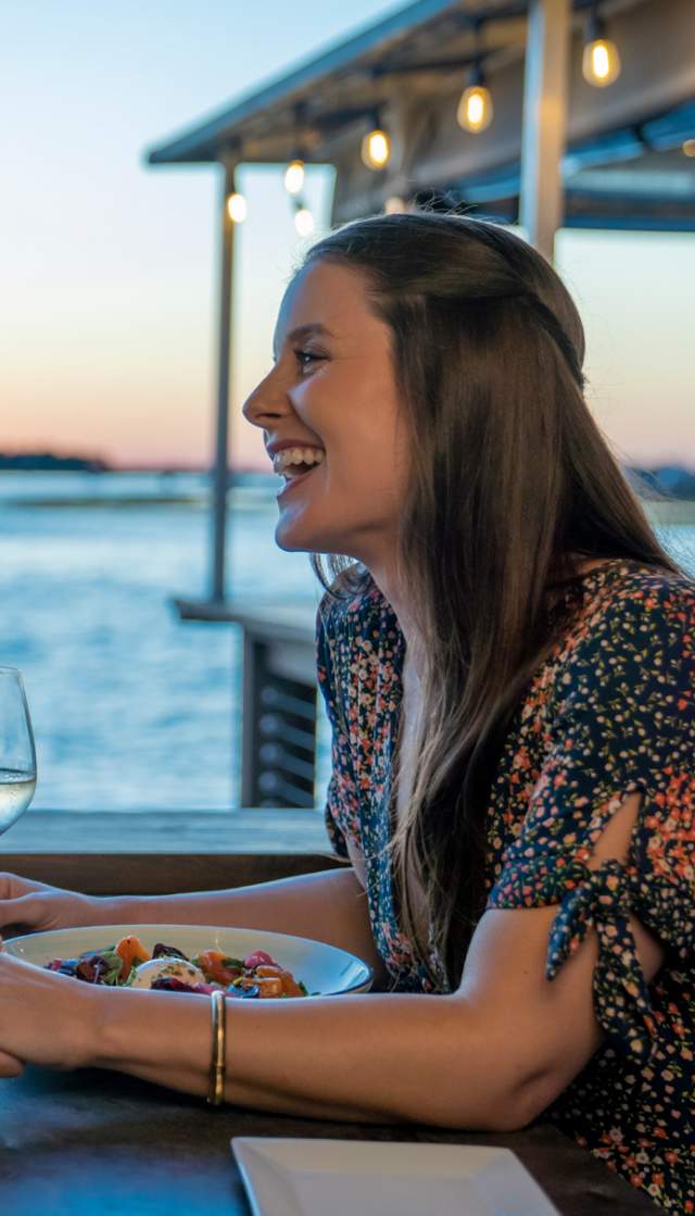 A couple having a waterfront meal in the evening in Southport, NC