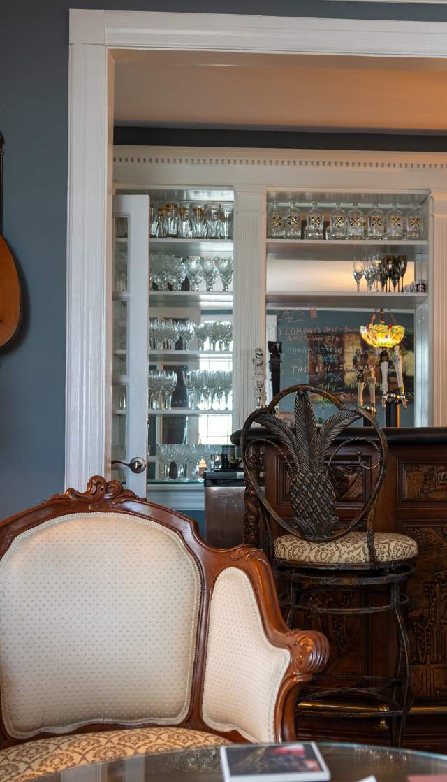 a parlor room with a bar and chairs