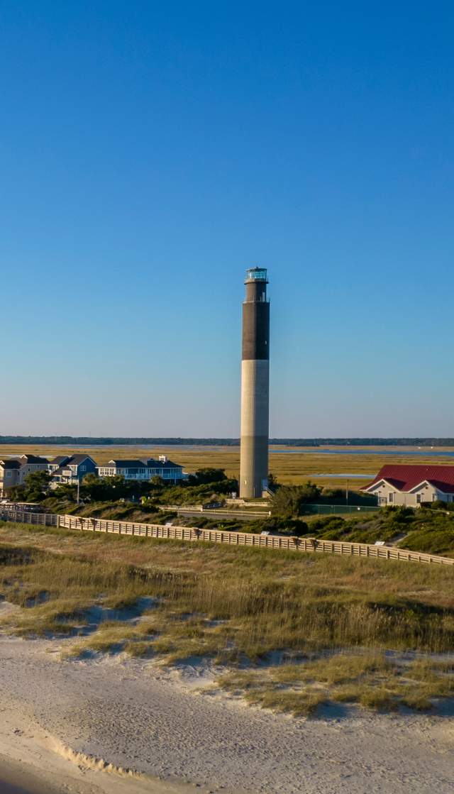 an aerial view of the OKI Lighthouse and Caswell Beach, NC
