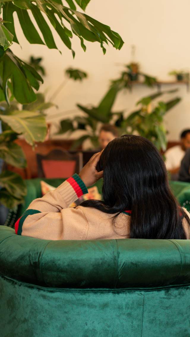 Young woman sitting on the sofa at Roots Plants and Coffee