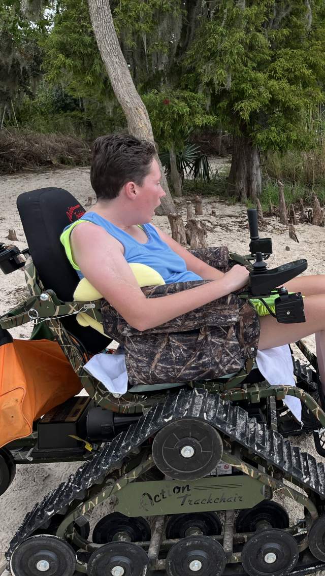 The author's daughter is seated in Fontainebleau State Park's all-track wheelchair on the beach inside the park.