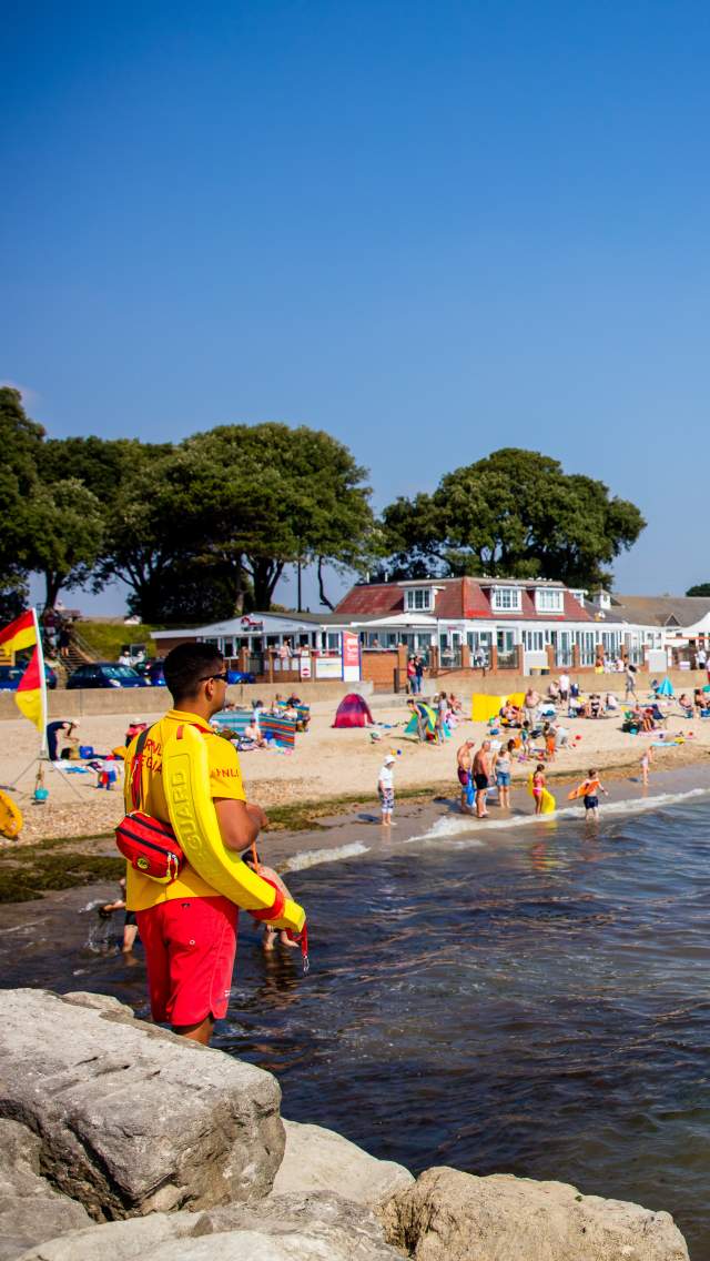 Lifeguard partrolling Avon Beach at Mudeford in Dorset