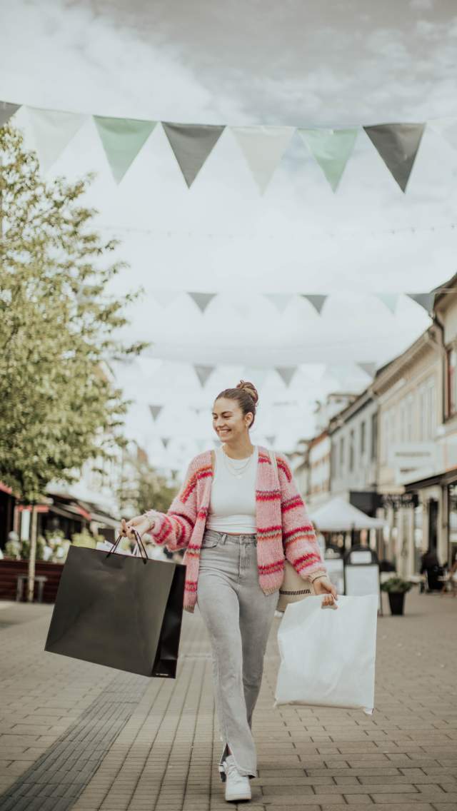 Kvinne på handleposer i hver hånd i gågata i Sarpsborg. Foto.