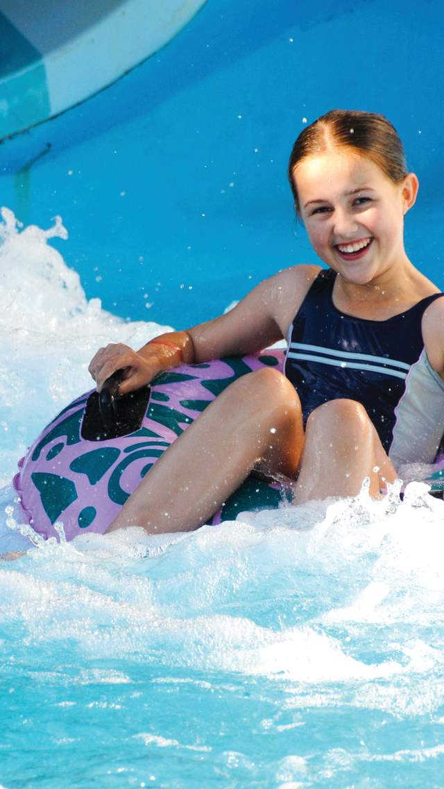 Girl riding down a flume at Splashdown Poole in Dorset